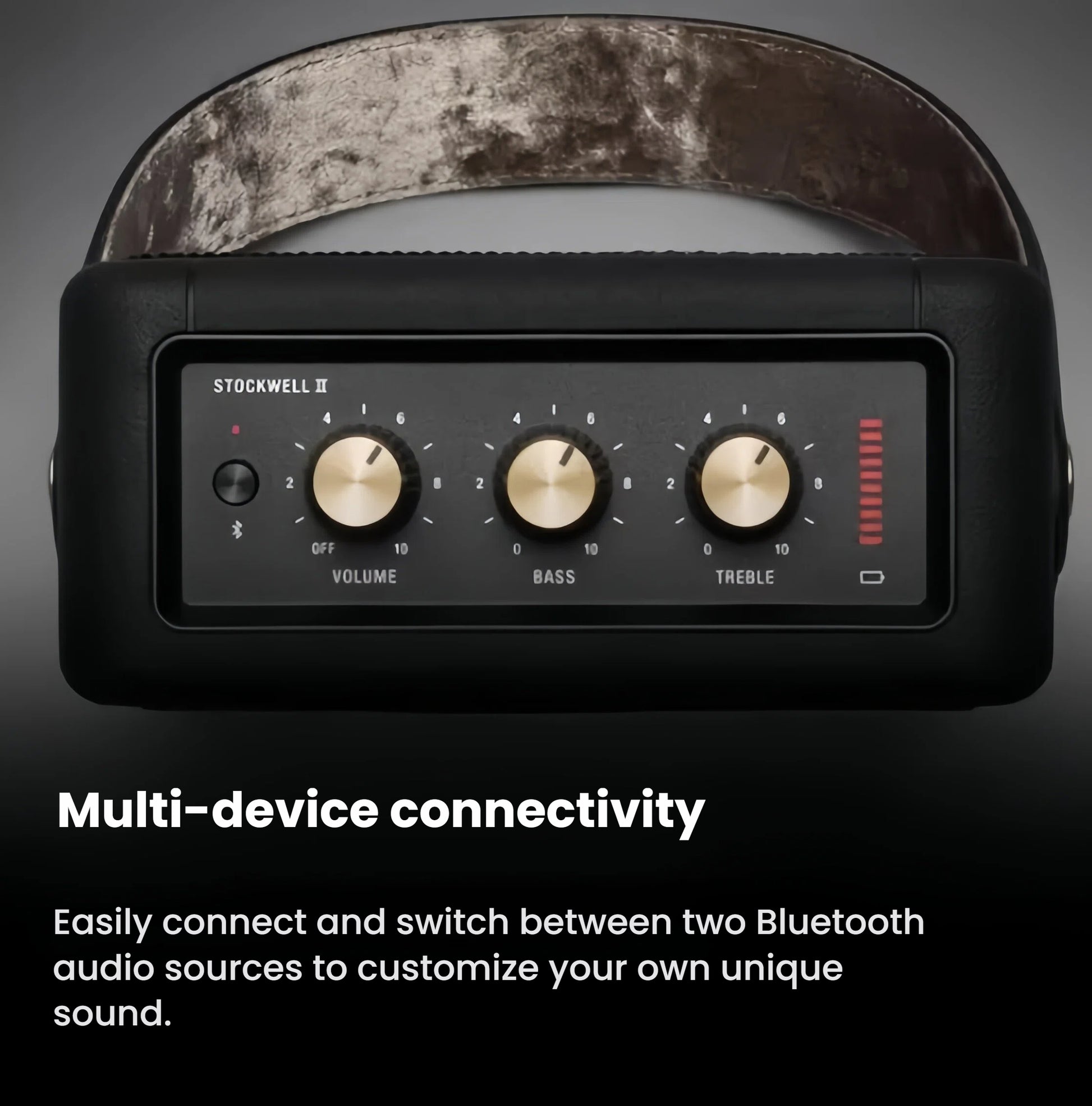 Close-up of the Marshall Stockwell II’s brass control knobs and LED battery indicator, illustrating easy switching between two Bluetooth audio sources.