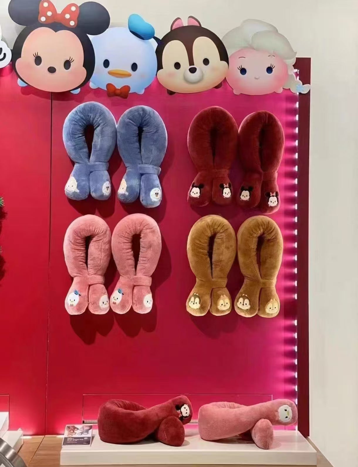 Display of multiple OSIM uSnooz massage wraps in various colors and Disney Tsum Tsum characters including Minnie Mouse, Donald Duck, Chip & Dale, and Daisy Duck. Showcased in a retail setting with vibrant lighting.
