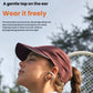Woman wearing white Shokz OpenDots One open-ear earbuds while playing tennis — innovative surround ear clip design allows safe, open listening without blocking ear canal.