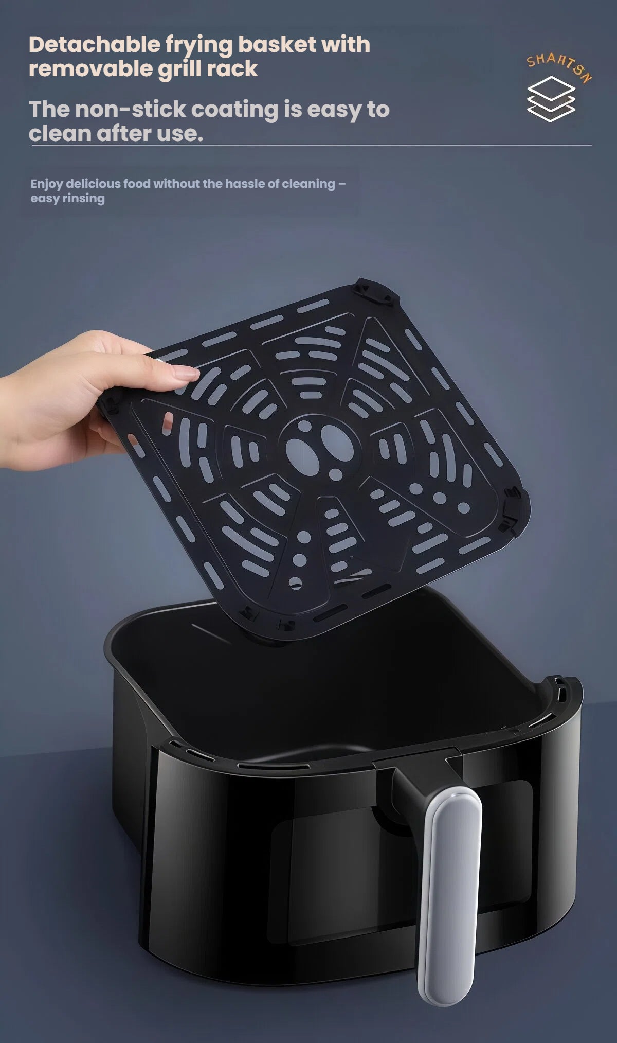 A close-up demonstrating the easy cleaning process of the Yamazen air fryer, showing a hand lifting the removable, non-stick grill rack from the detachable frying basket.